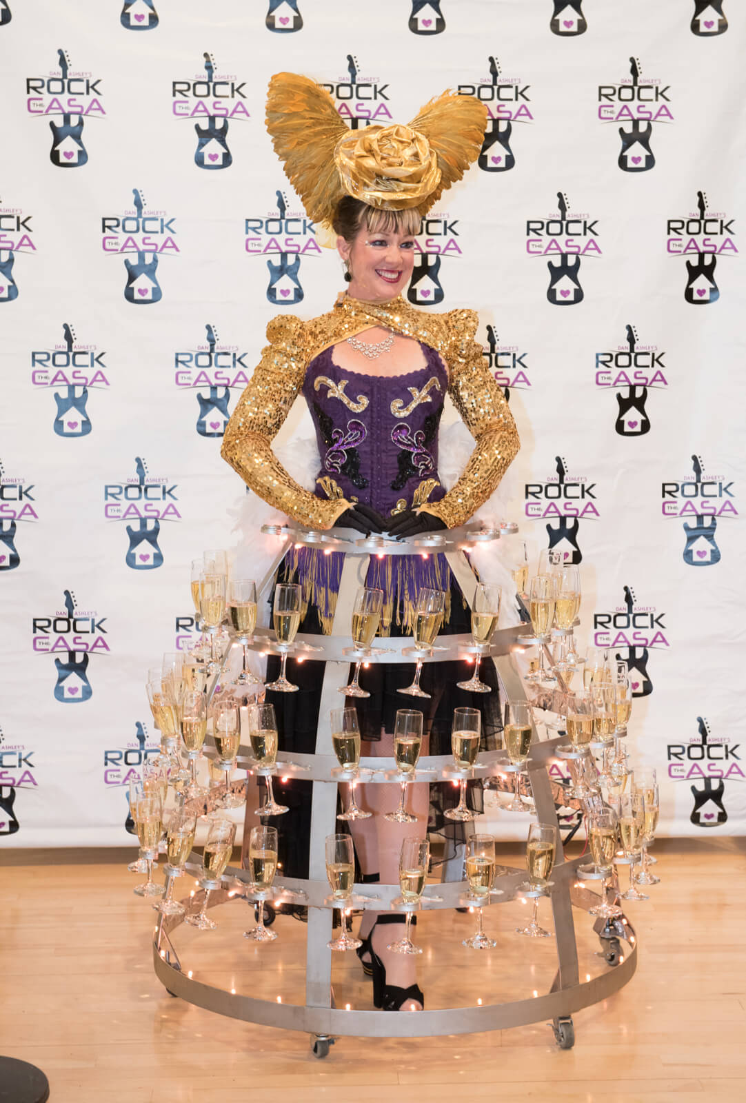 Woman at event dressed in dress made of champagne glasses