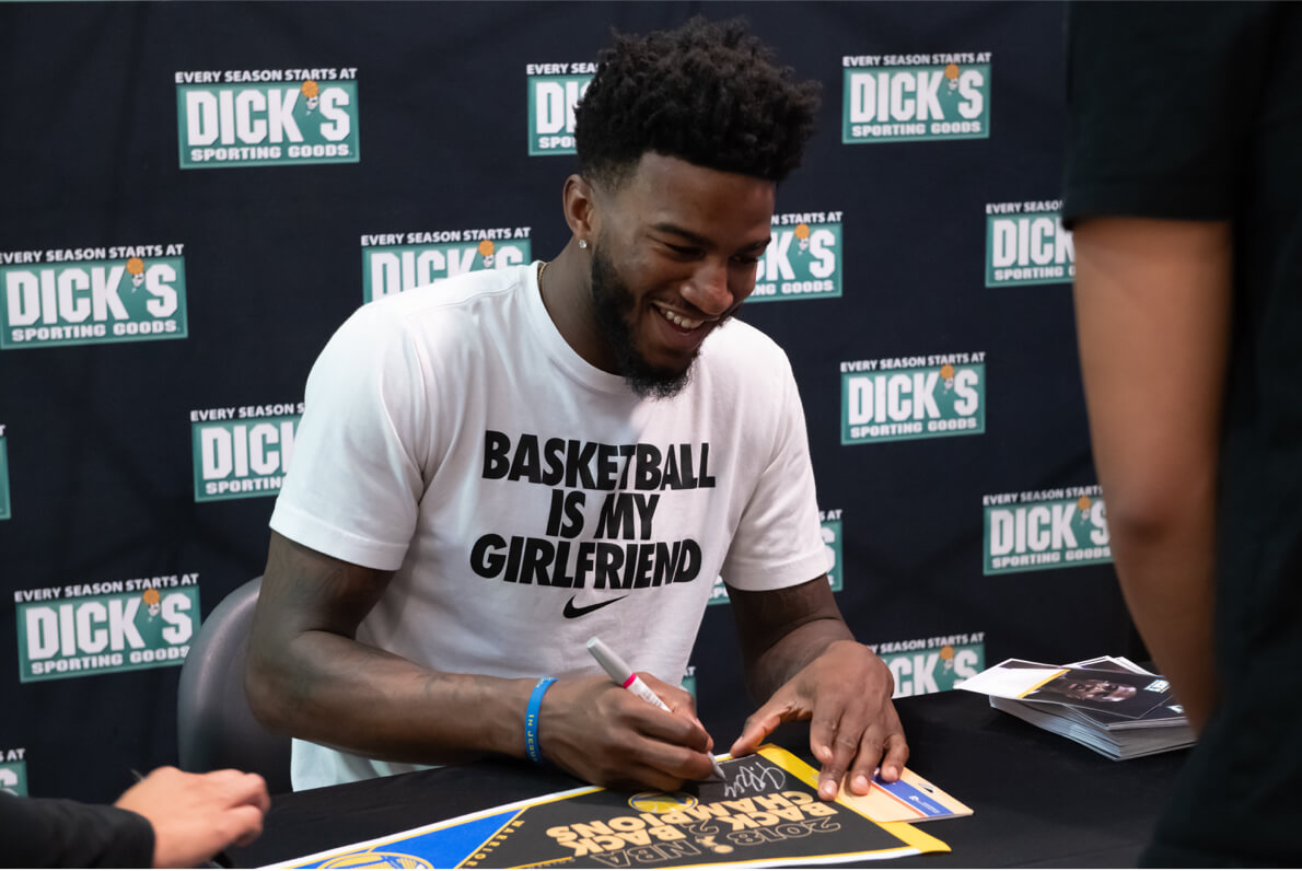 Golden State Warriors play signs an autograph at a charity event