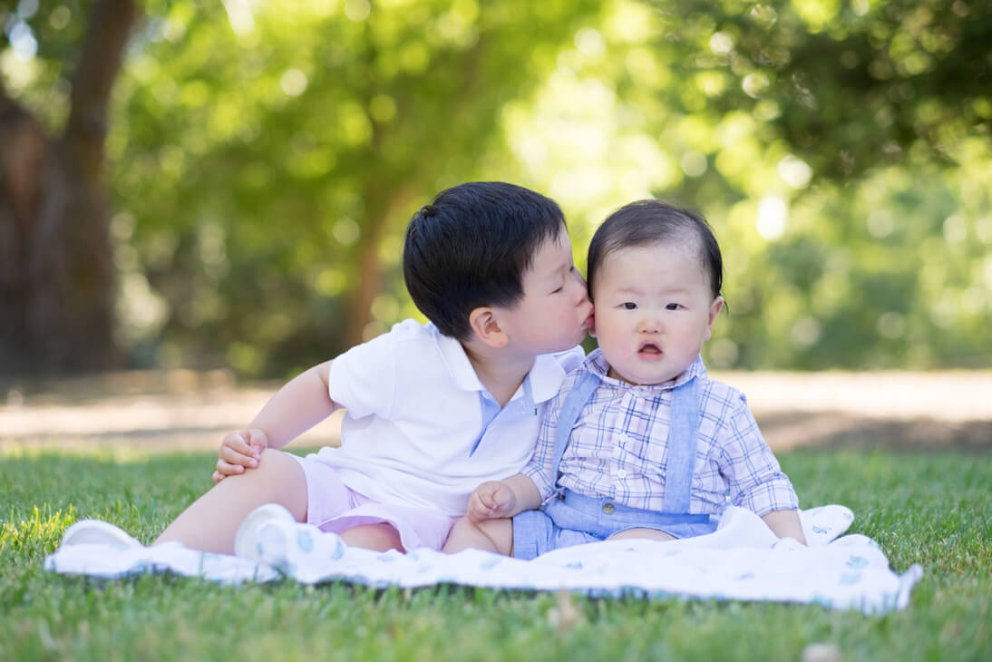 Potrait fo two brothers on a blanket in the park