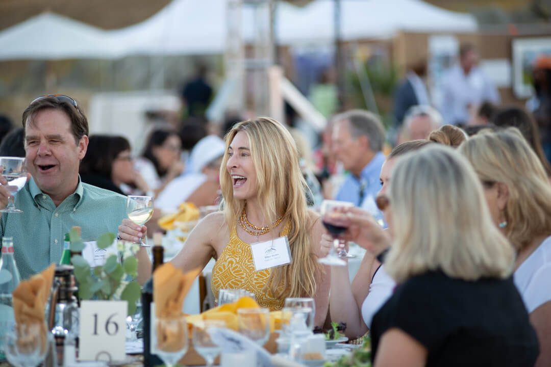 People laughing sitting at a table a charity event